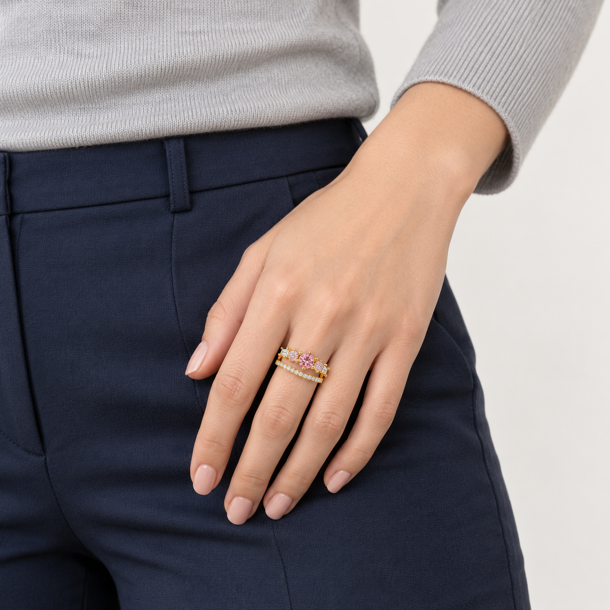 Anillo ajustable dorado de centro rosa y doble banda — combinación con ropa; imagen ilustrativa generada con IA, escala no verificada.