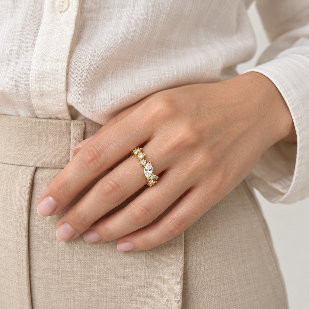 Anillo ajustable dorado de hoja central y flores — combinación con ropa; imagen ilustrativa generada con IA, escala no verificada.