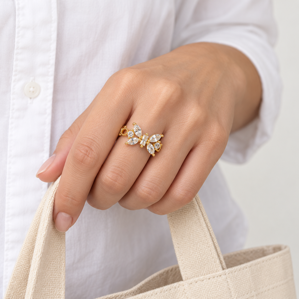 Anillo ajustable dorado de mariposa transparente — gesto cotidiano; imagen ilustrativa generada con IA, escala no verificada.