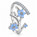 Anillo plateado de flores azules y ramas