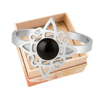 Anillo abierto de acero plateado con diseño de Nudo de Bruja y piedra central de Ágata Negra redonda.