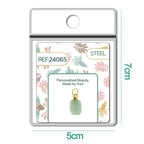 Detalle de charm colgante de piedra verde rectangular con aro de acero