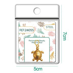 Detalle de charm colgante de tortuga dorada con aro de acero