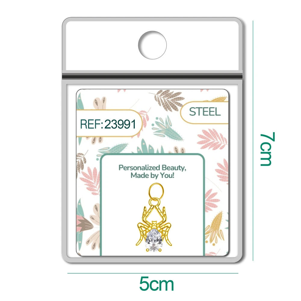 Charm dorado de araña con circonita de lágrima con aro de acero, en blíster