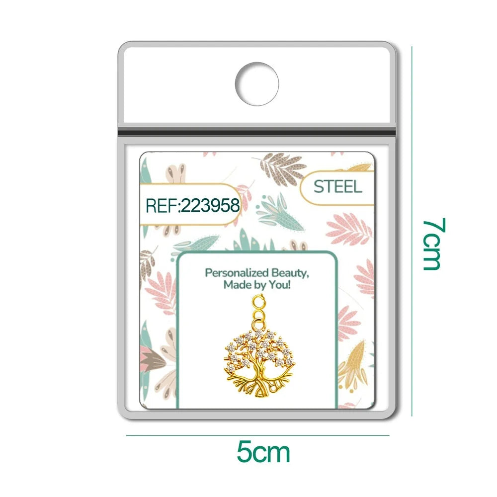 Charm de árbol de la vida dorado con raíces y circonitas con cierre de acero en blíster