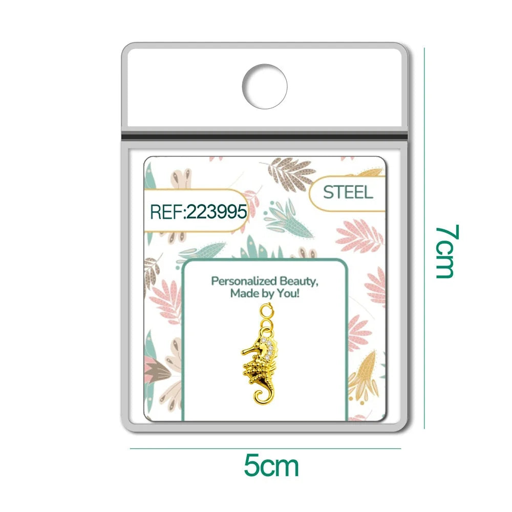 Charm dorado de caballito de mar con circonitas con cierre de acero, en blíster