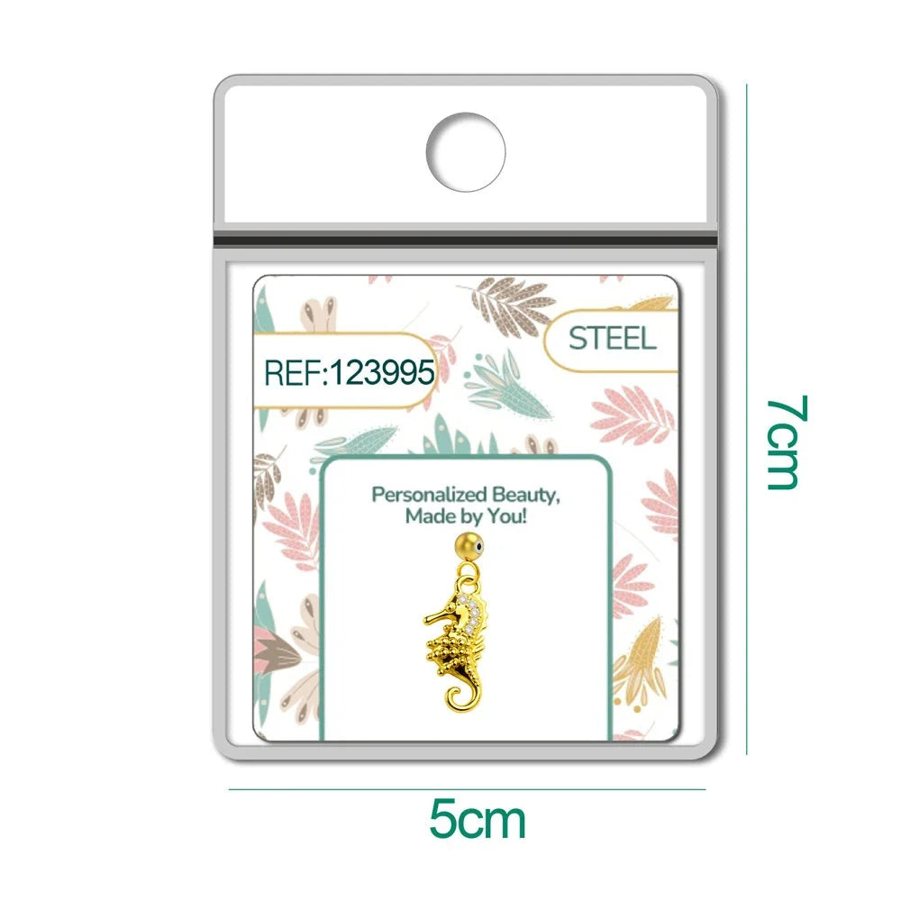 Charm dorado de caballito de mar con circonitas con bola de acero con goma, en blíster