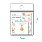 Charm de concha dorado con circonita central y bola de acero con goma, detalle