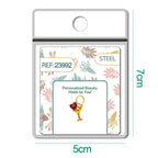 Charm dorado de copa de cóctel con corazón rojo con aro de acero, en blíster