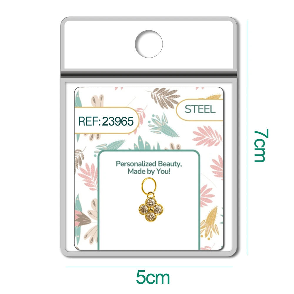 Charm de flor de cuatro pétalos dorado con circonitas en blíster, vista frontal