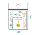 Charm dorado de sol con cara y seis circonitas con cierre de acero, en blíster