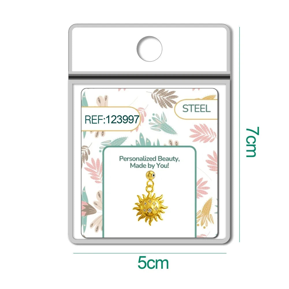 Charm dorado de sol con cara y seis circonitas con bola de acero con goma, en blíster