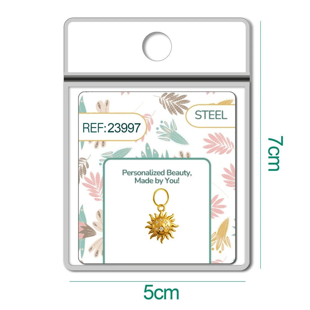 Charm dorado de sol con cara y seis circonitas con aro de acero, en blíster