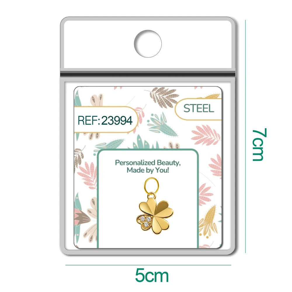 Charm dorado de trébol con tres circonitas con aro de acero, en blíster