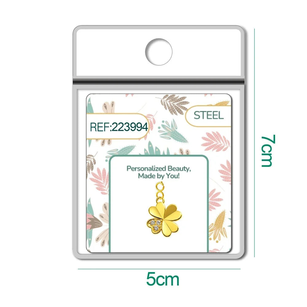 Charm dorado de trébol con tres circonitas con cierre de acero, en blíster
