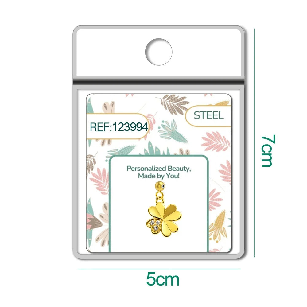 Charm dorado de trébol con tres circonitas con bola de acero con goma, en blíster