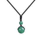 Colgante con bola verde de piedra de 14 mm sujeta por trenzado y cordón negro