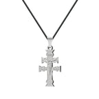 Colgante Cruz de Caravaca en acero inoxidable con figura de Cristo en relieve, inscripciones grabadas y cordón negro