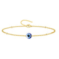 Pulsera de cadena fina dorada con colgante de ojo turco azul central y cierre de mosquetón ajustable.
