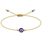 Pulsera de cordón dorado fino con amuleto central de ojo turco azul y detalles de cuentas doradas ajustables.